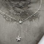 Sterling silver necklace decorated with flower and another dangly flower